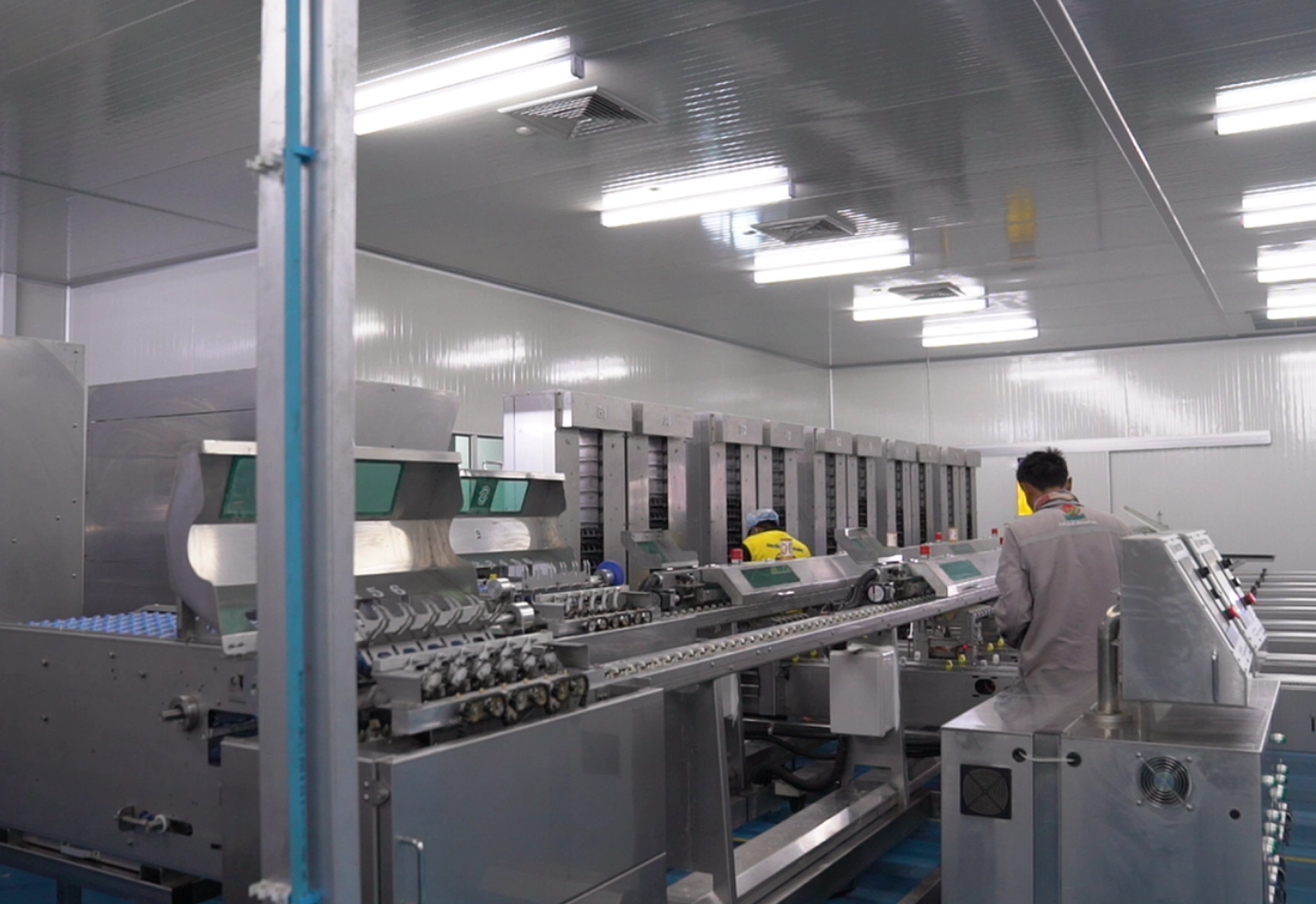 A Factory Interior Showing Machines And Workers Engaged In Various Tasks